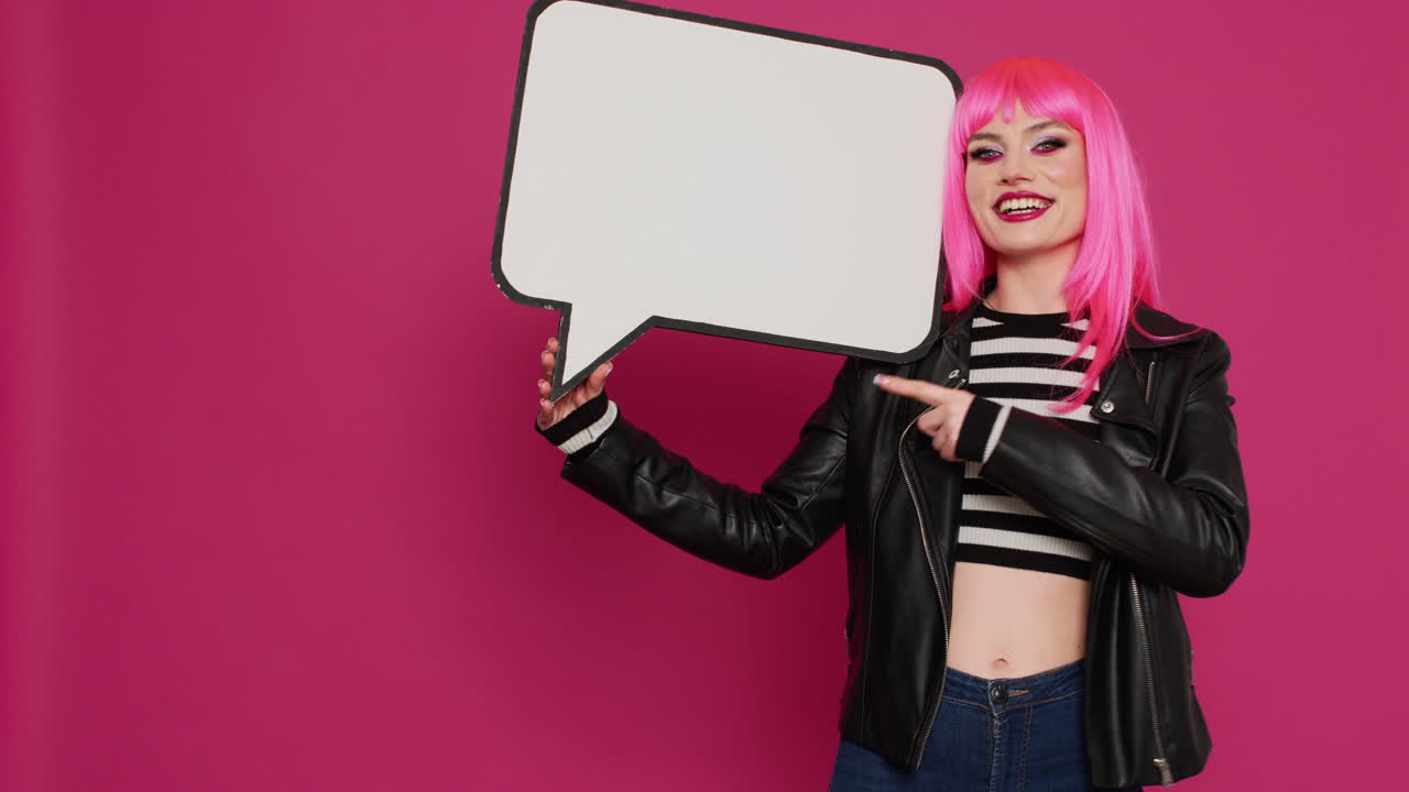 Punk carefree woman holding blank speech bubble in studio