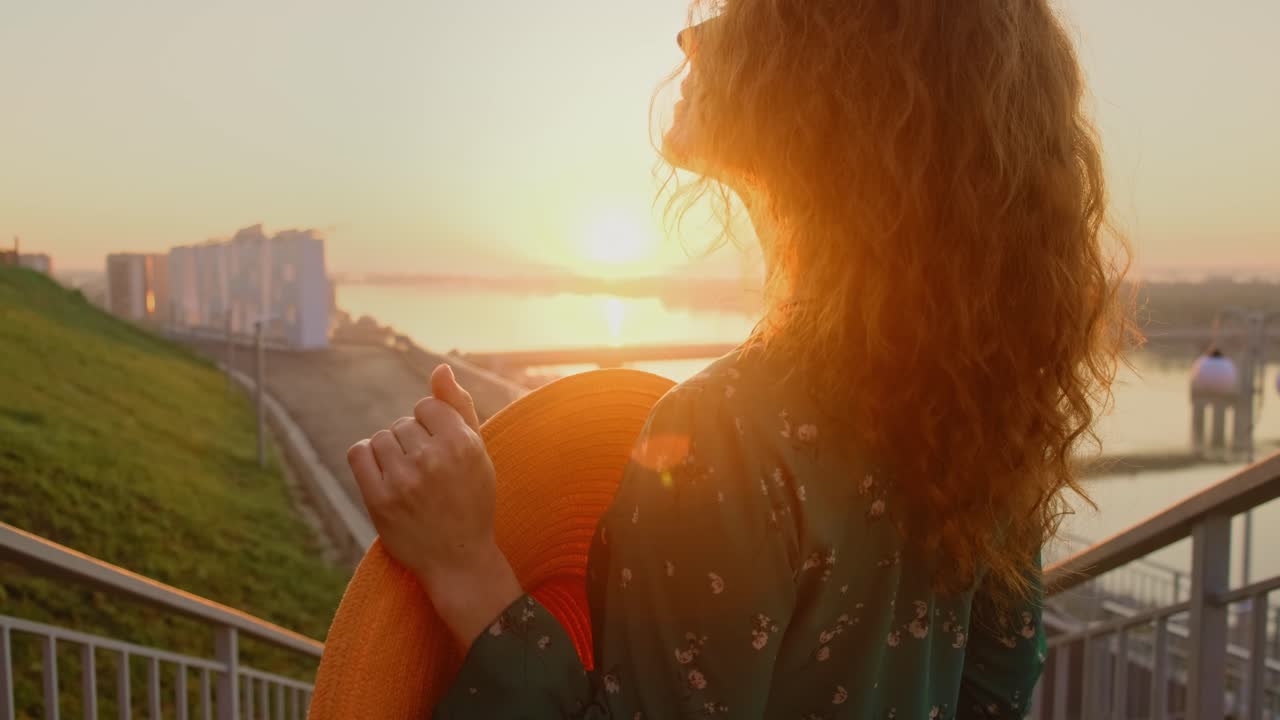Woman watching sunrise/sunset from balcony