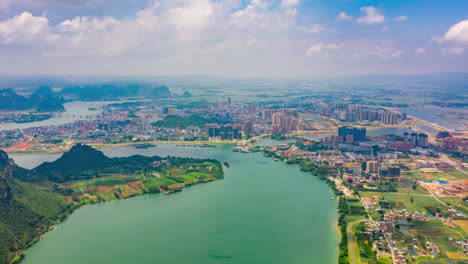 aerial view of a vibrant city nestled beside a winding river with majestic mountains in the background