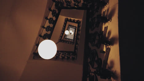 beautiful slow motion shot with contrapicado angle of a staircase inside an elegant enclosure and a circular house spotlight.