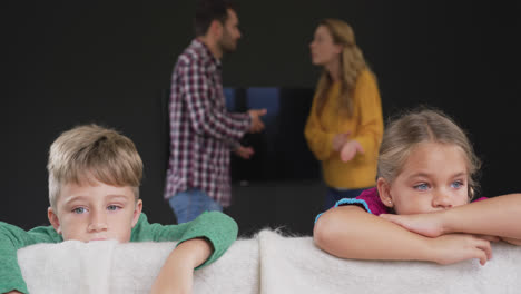 Kinder-Lehnen-Sich-Auf-Dem-Sofa,-Während-Die-Eltern-Zu-Hause-Im-Hintergrund-Streiten,-4K