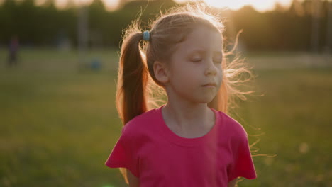 upset little girl with swollen eyelid turns head on field