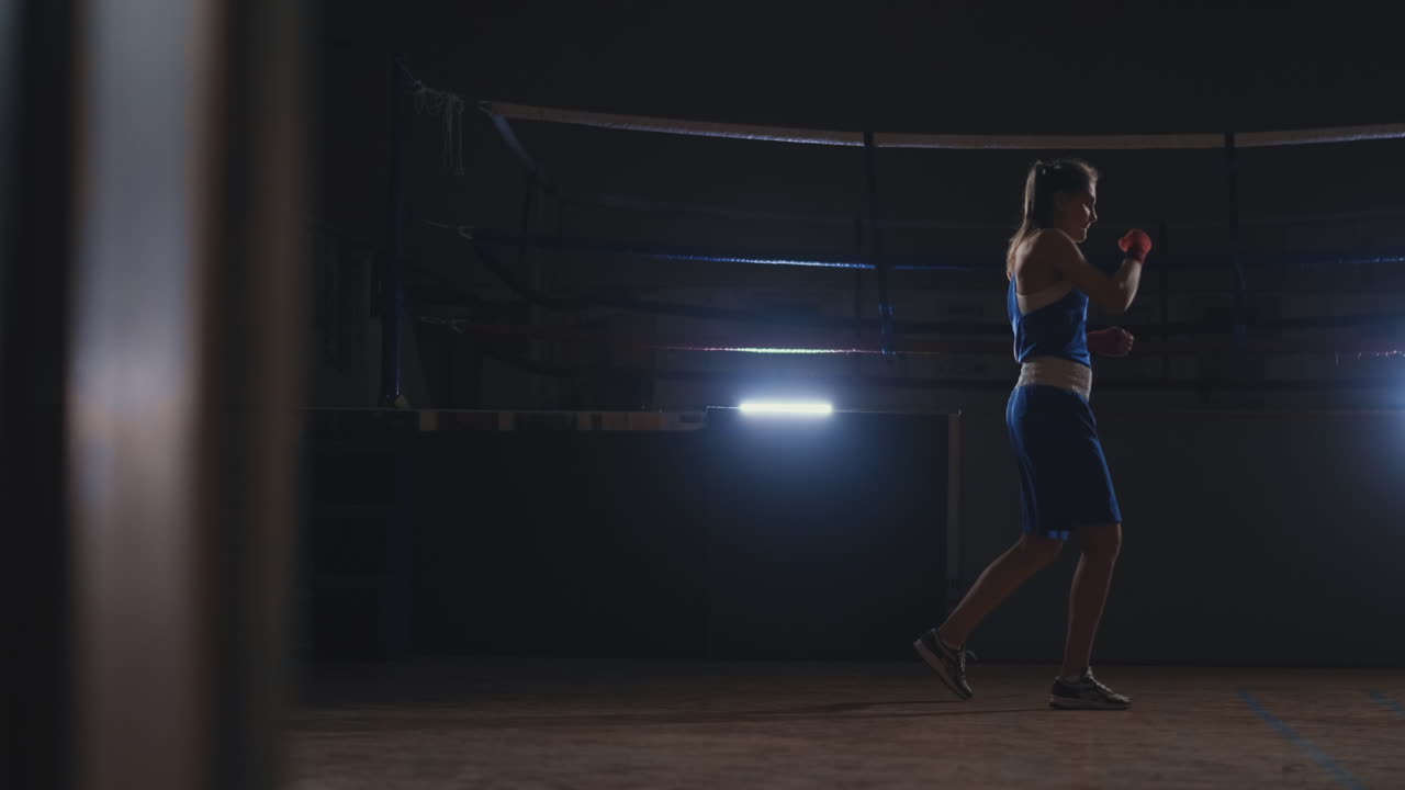 Donna atletica che fa esercizi di fitness per la boxe e pratica tecniche di autodifesa. Ripresa steadicam.