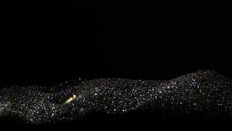 9×19mm parabellum cartridges dropping into heap of bullet grains