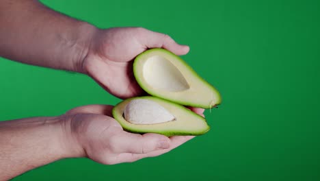 abriendo un aguacate recién cortado a la mitad.