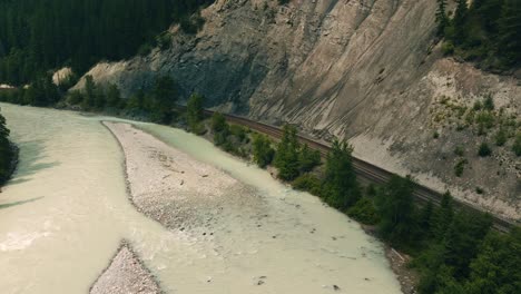 Vista-Aérea-De-Primer-Plano-Del-Ferrocarril-Del-Pacífico-Canadiense-Siguiendo-El-Río-Kicking-Horse