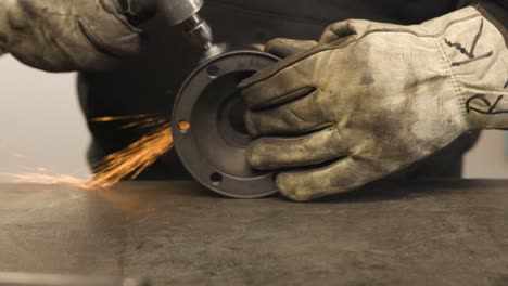 close up of man angle grinding a hub