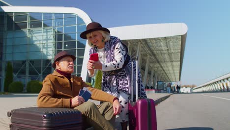 turistas jubilados abuela abuelo comprar boletos en línea en el teléfono móvil cerca del aeropuerto