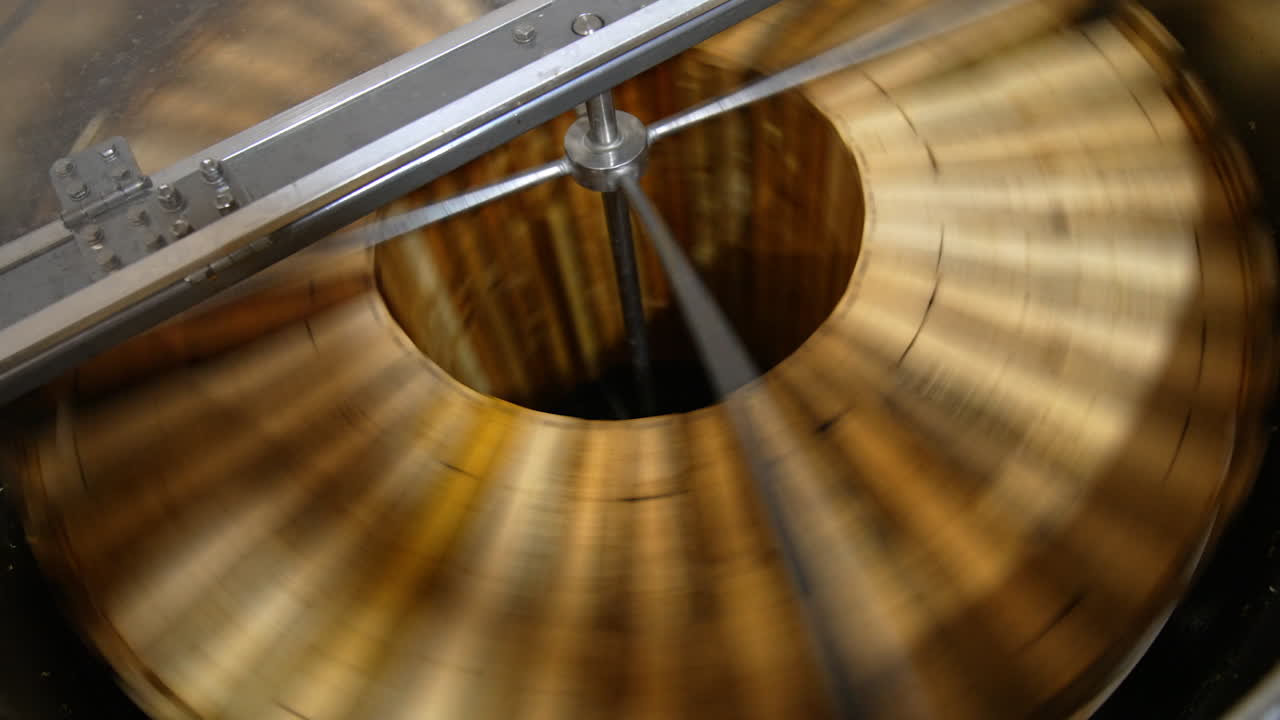 Production of healthy organic honey in the apiary. Honey extracting machine spinning the wooden frames. Top view.