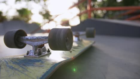 close-up shot of skateboard on the ground in sun beams