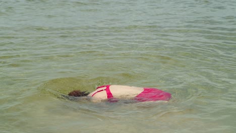 radiating tropical allure, a curly-haired latina charms the beach scene in a sexy bikini