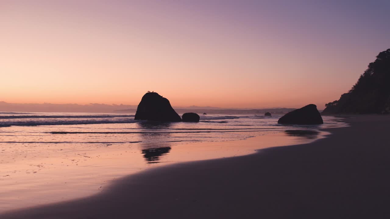 amanecer mágico con colores vibrantes en la playa de marea baja con rocas