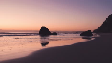 magical morning sunrise with vibrant colors at low tide beach with boulders