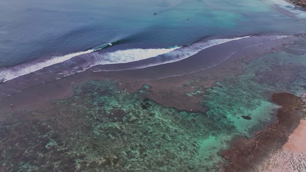 fotografía de drones de surfistas montando olas perfectas en un popular destino de surf y vacaciones en la isla de bali