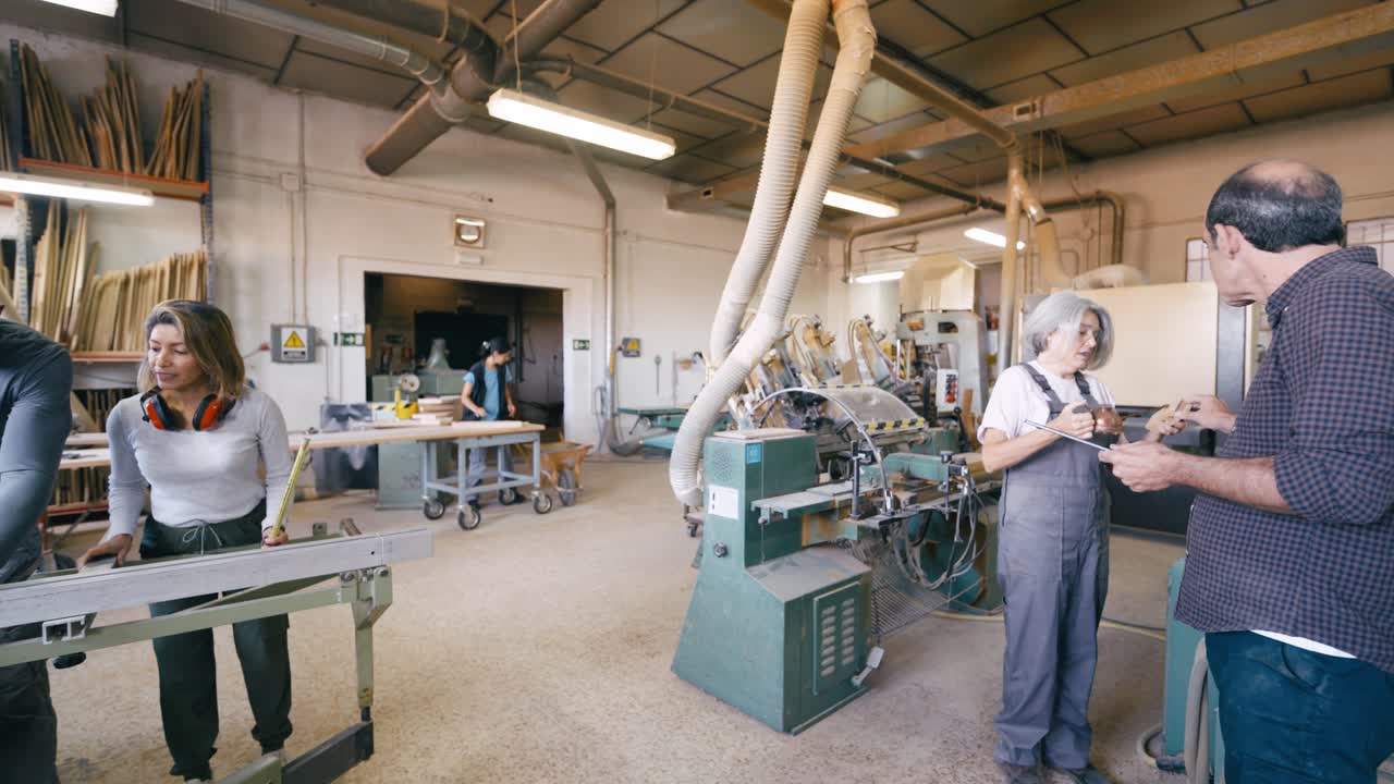 Diverse Team of Carpenters Working and Discussing in a Woodworking Workshop