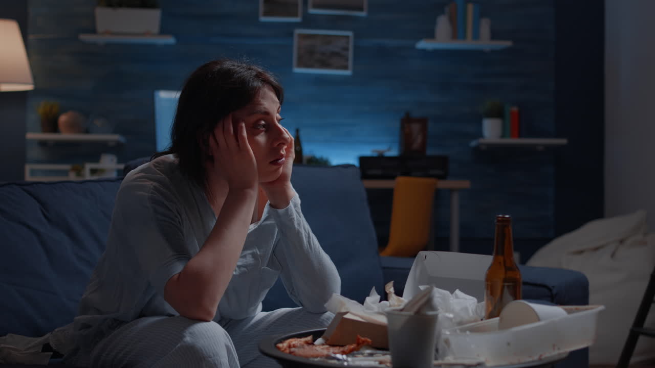 Chiuda sulla giovane donna depressa frustrata esausta che massaggia le tempie