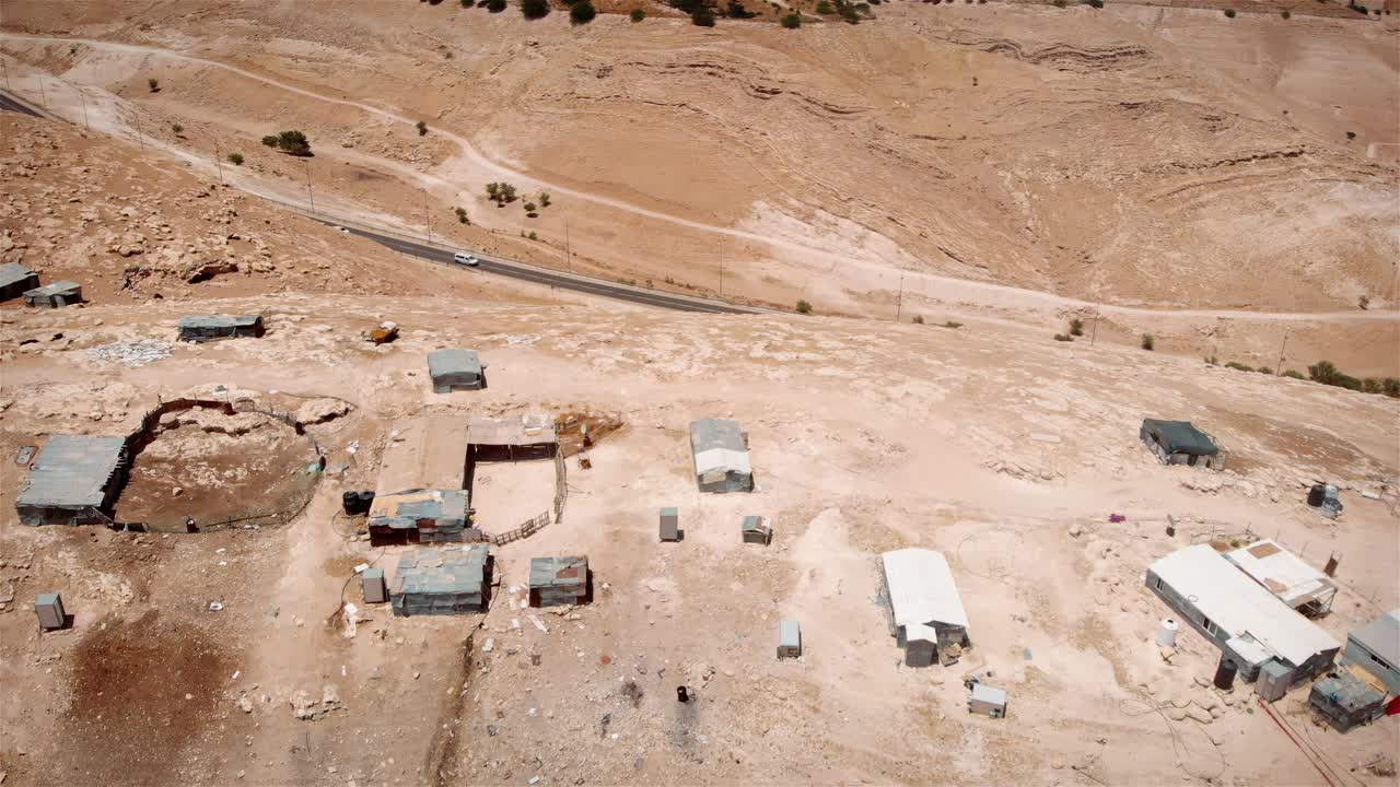 Aerial View of a Desert Settlement with Shacks and Road