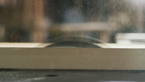 close up of professional carpenter working on woodworking machines in a workshop of a wood factory.