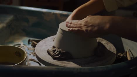 Young-female-potter-working-in-her-studio