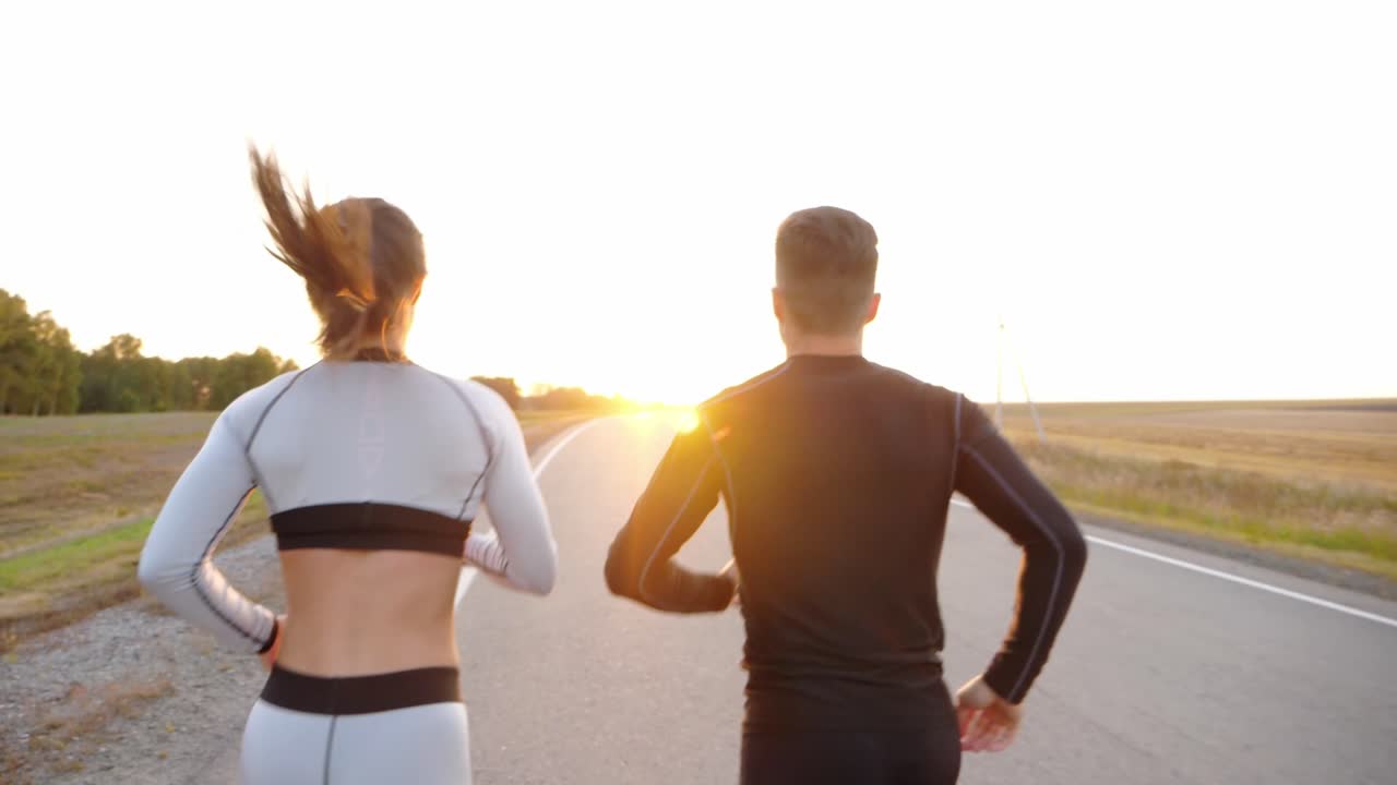 Couple Running on a Road at Sunset