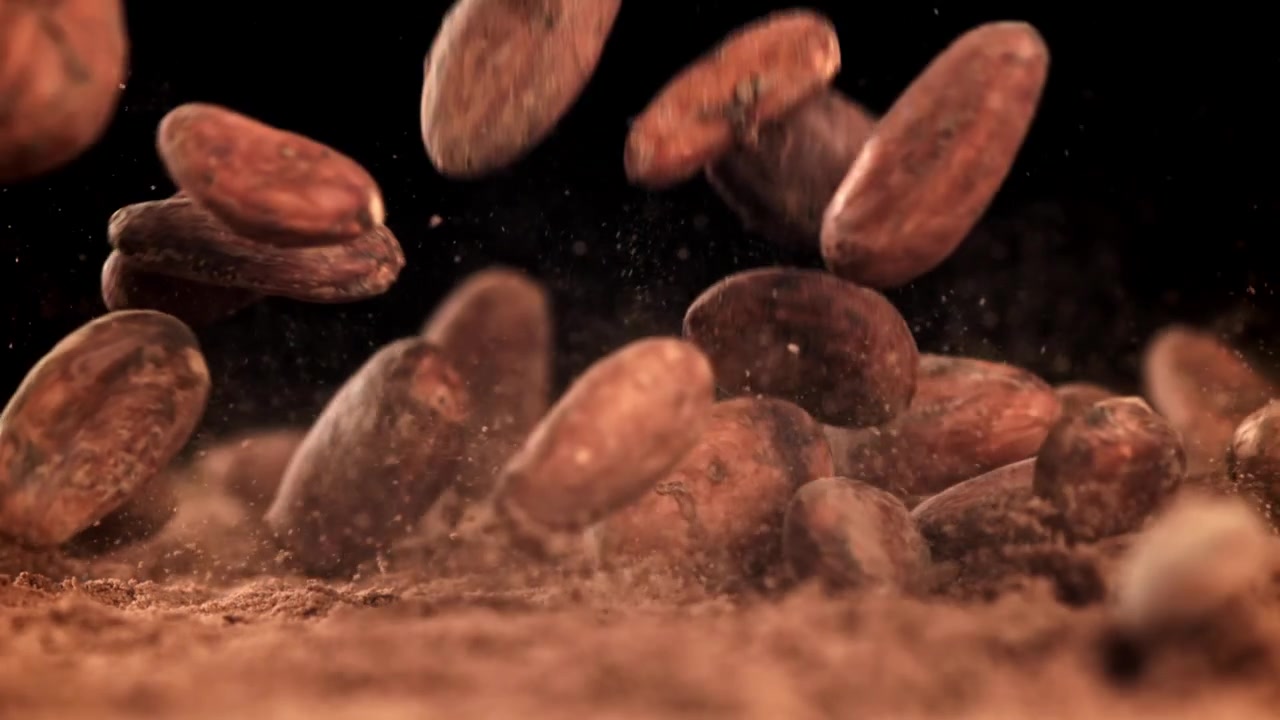 Granos de cacao cayendo sobre cacao en polvo en cámara lenta