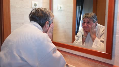 mujer lavando la cara en el baño