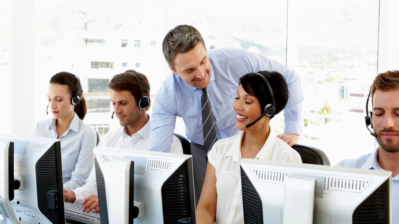 gerente chequeando a los trabajadores del centro de llamadas