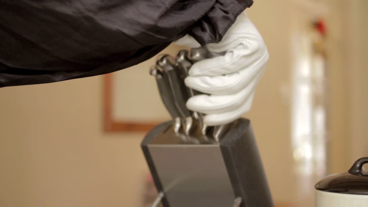 Knife being grabbed by gloved hand