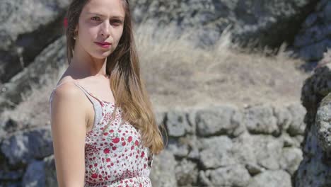 woman in a dress by a rocky outcrop