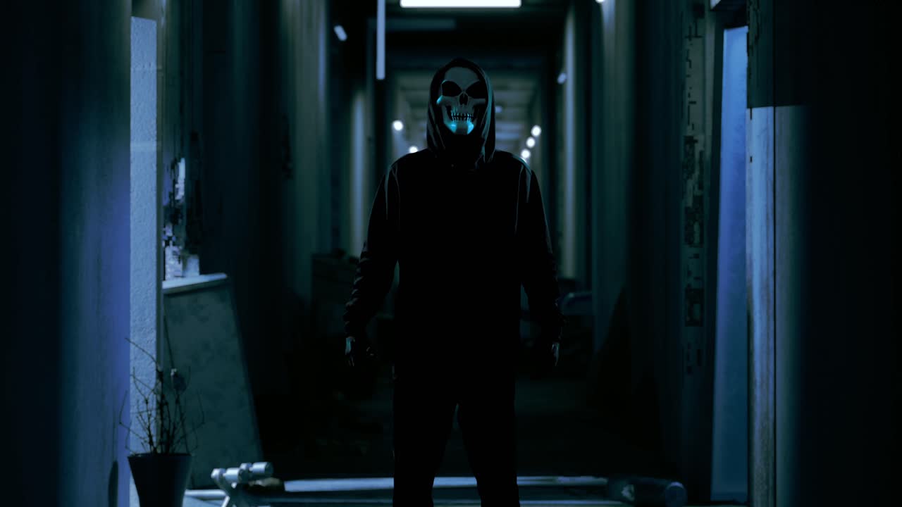 버려진 호텔에 서 있는 유령 마스크를 입은 허드 인 무서운 남자, 공포 장면