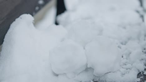 primer plano en cámara lenta de agarrar y quitar una pila de bolas de nieve con guantes negros