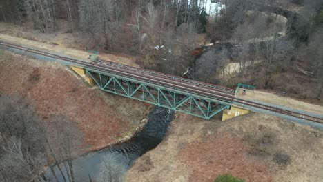 antena: vías de tren en la parte superior del puente construido sobre el río que fluye