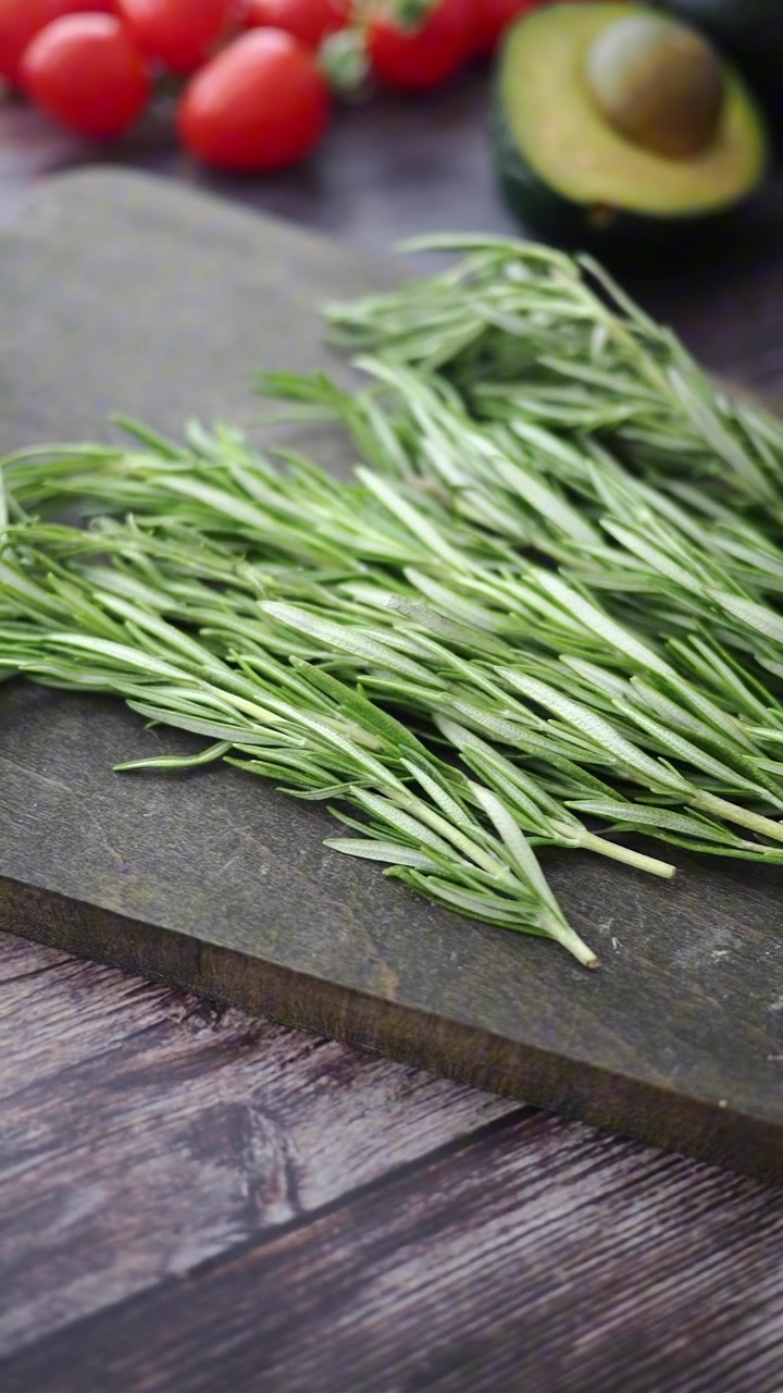 Fresh Rosemary Sprigs on a Dark Wooden Cutting Board