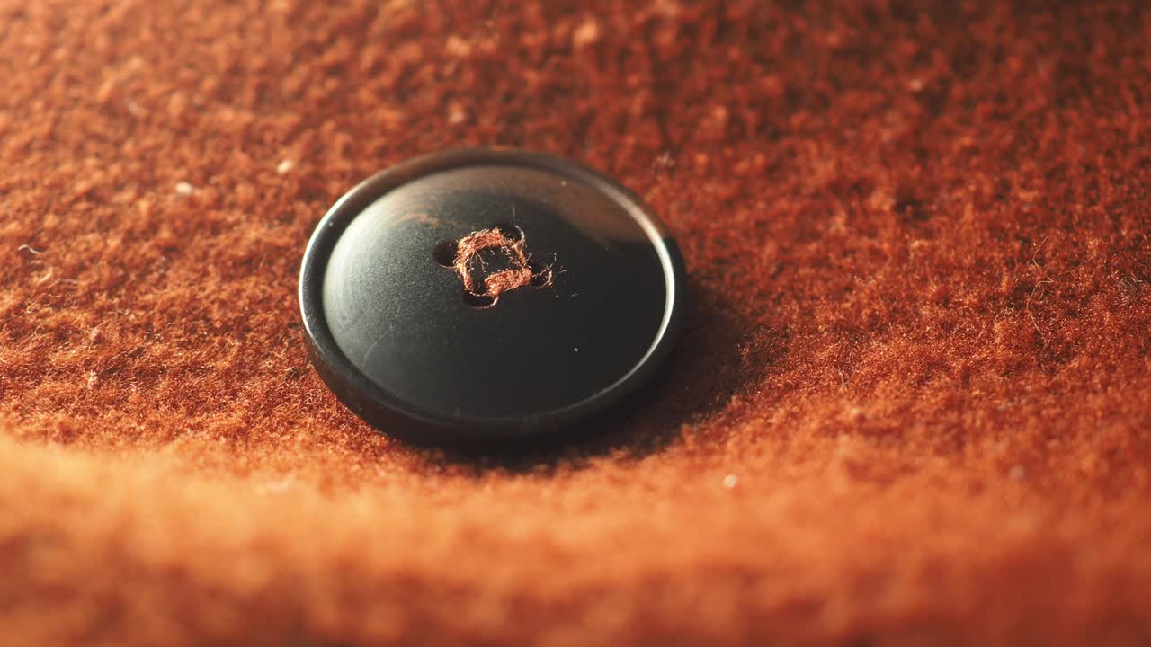 Close-up of a Black Button on Brown Fabric