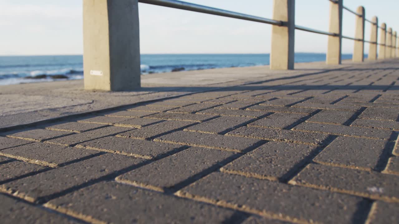 해변의 산책로에서 달리는 스포츠 의류를 입은 아프리카계 미국인 여성의 낮은 부분