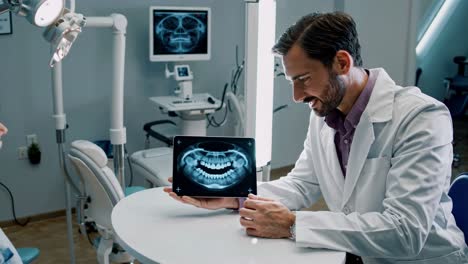 el dentista muestra rayos x al paciente