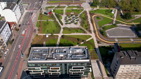 top down aerial over the central park in gdynia - modern urban space next to a busy street and modern office buildings