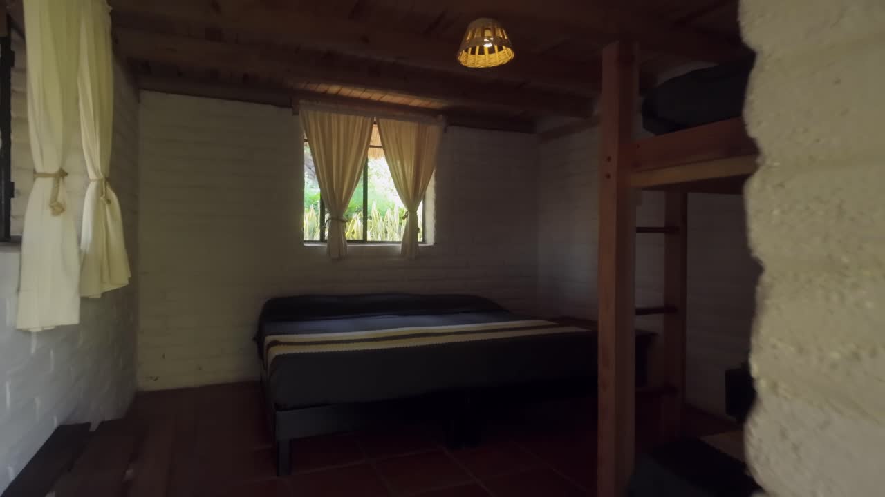 Dolly-in shot of cozy bedroom with rustic decor inside a superadobe home