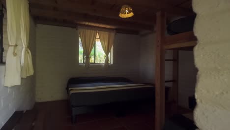 dolly-in shot of cozy bedroom with rustic decor inside a superadobe home