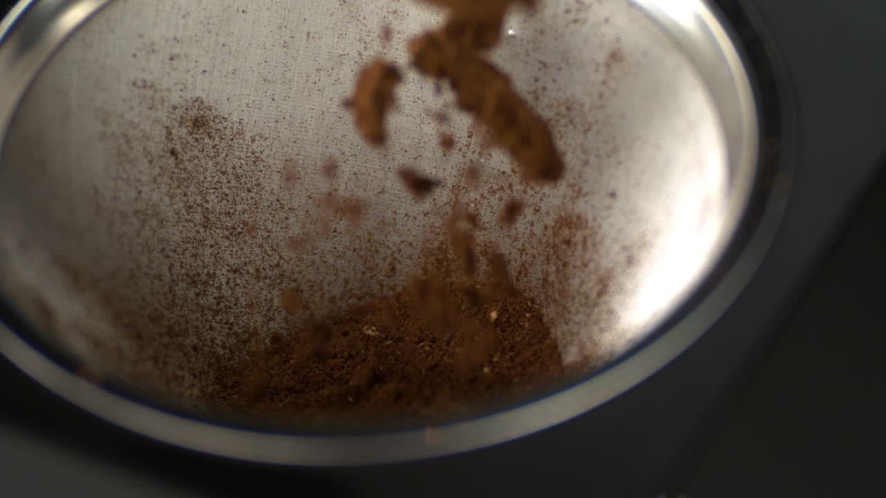 Caffè macinato che cade nel filtro di una macchina da caffè in super slow motion