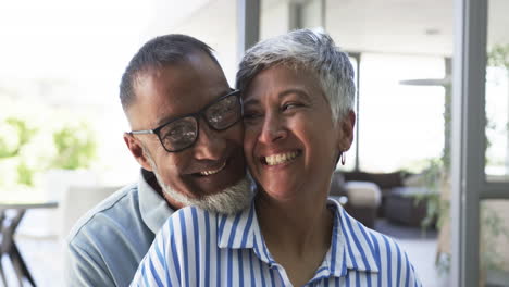 biracial couple shares a joyful embrace, both with greying hair
