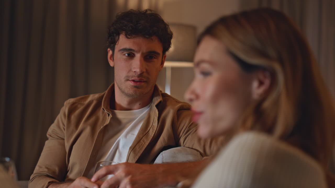 Romantic lovers talking sofa enjoying evening date in apartment close up