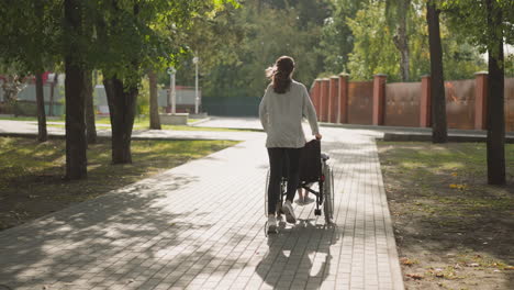 mother runs on pavement pushing wheelchair with daughter