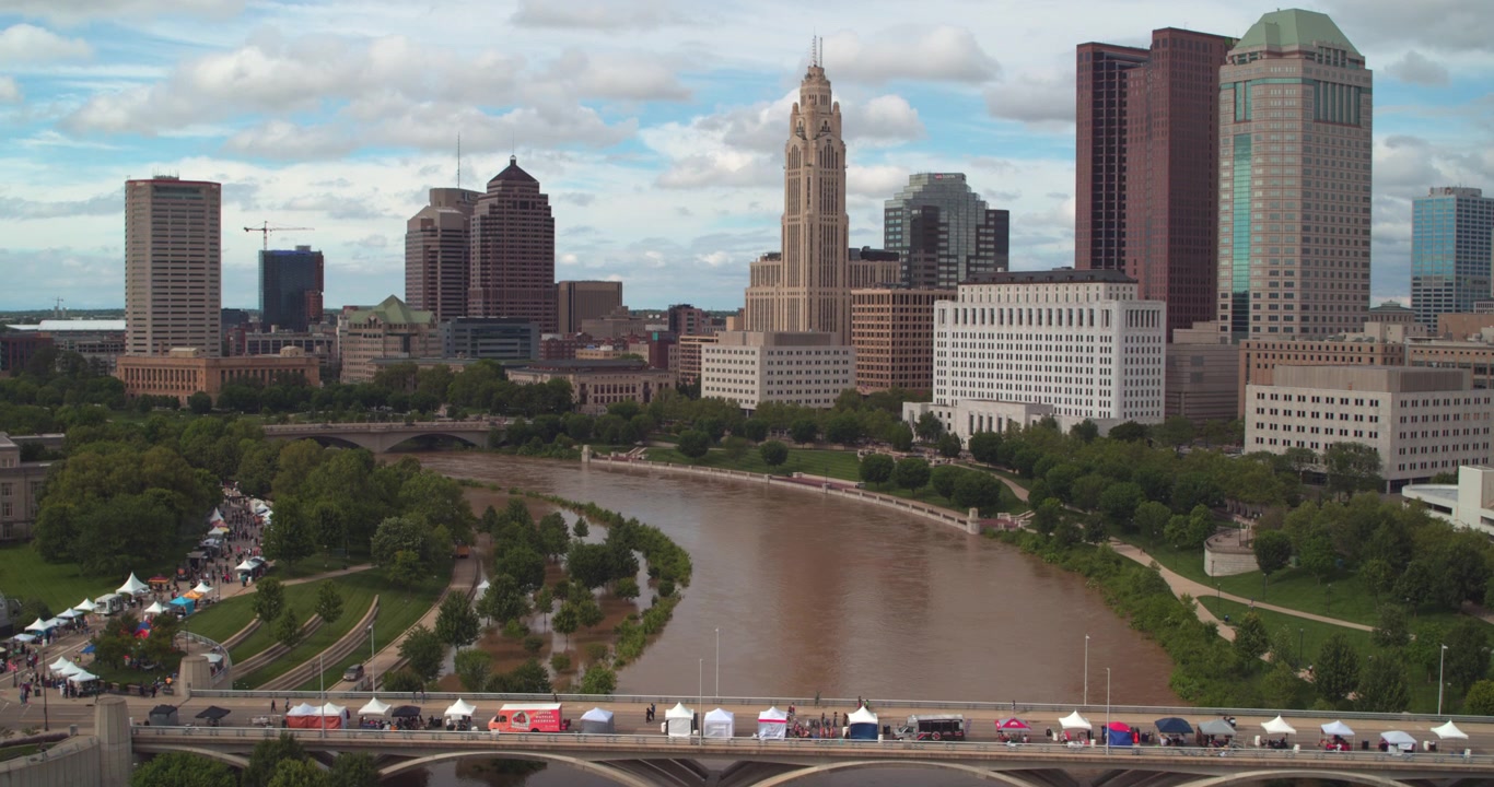 Denna etablerande flygdrönarbild fångar Columbus, Ohios stadssilhuett i centrum, och visar stadens kluster av skyskrapor inklusive det ikoniska LeVeque Tower och andra moderna höghus.
