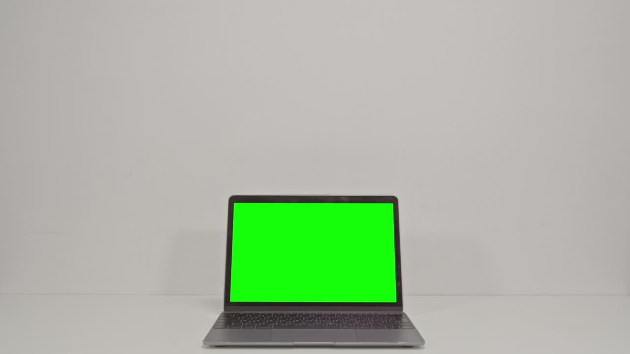 Laptop dark silver mockup with green screen isolated on white background.