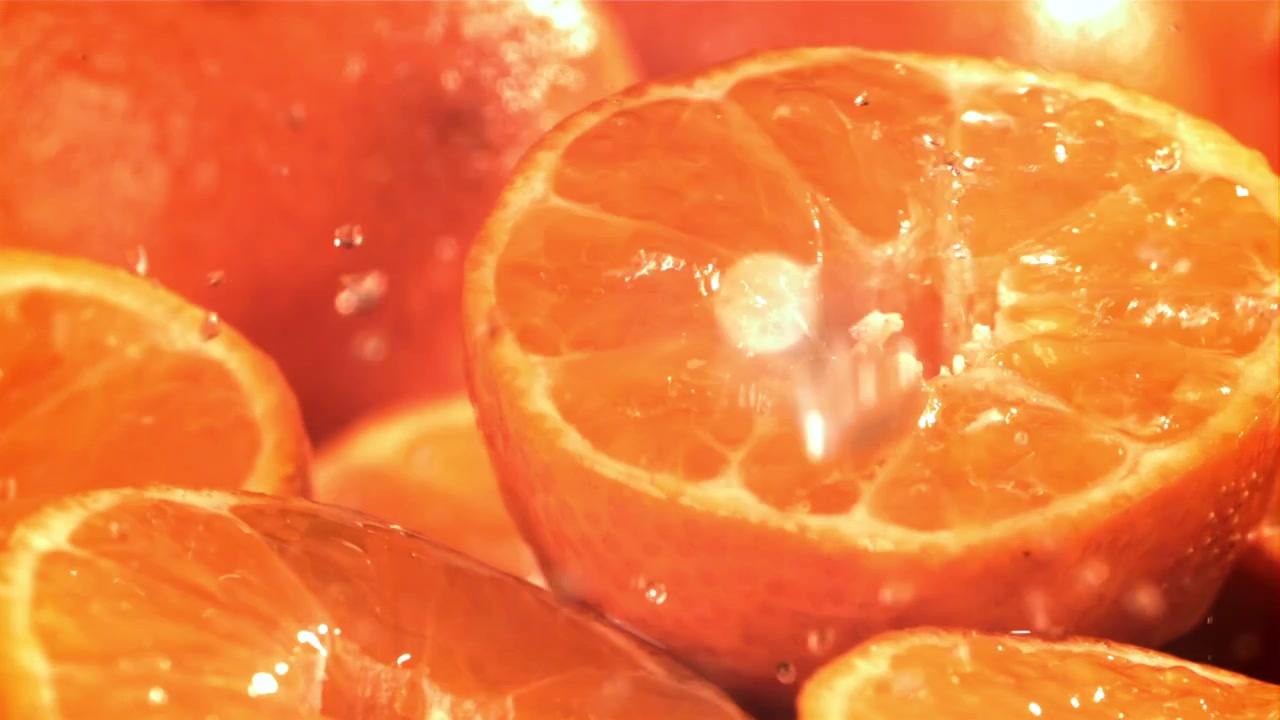 Erfrischendes Wasser spritzt auf leuchtend orangefarbene Zitrusfrucht.