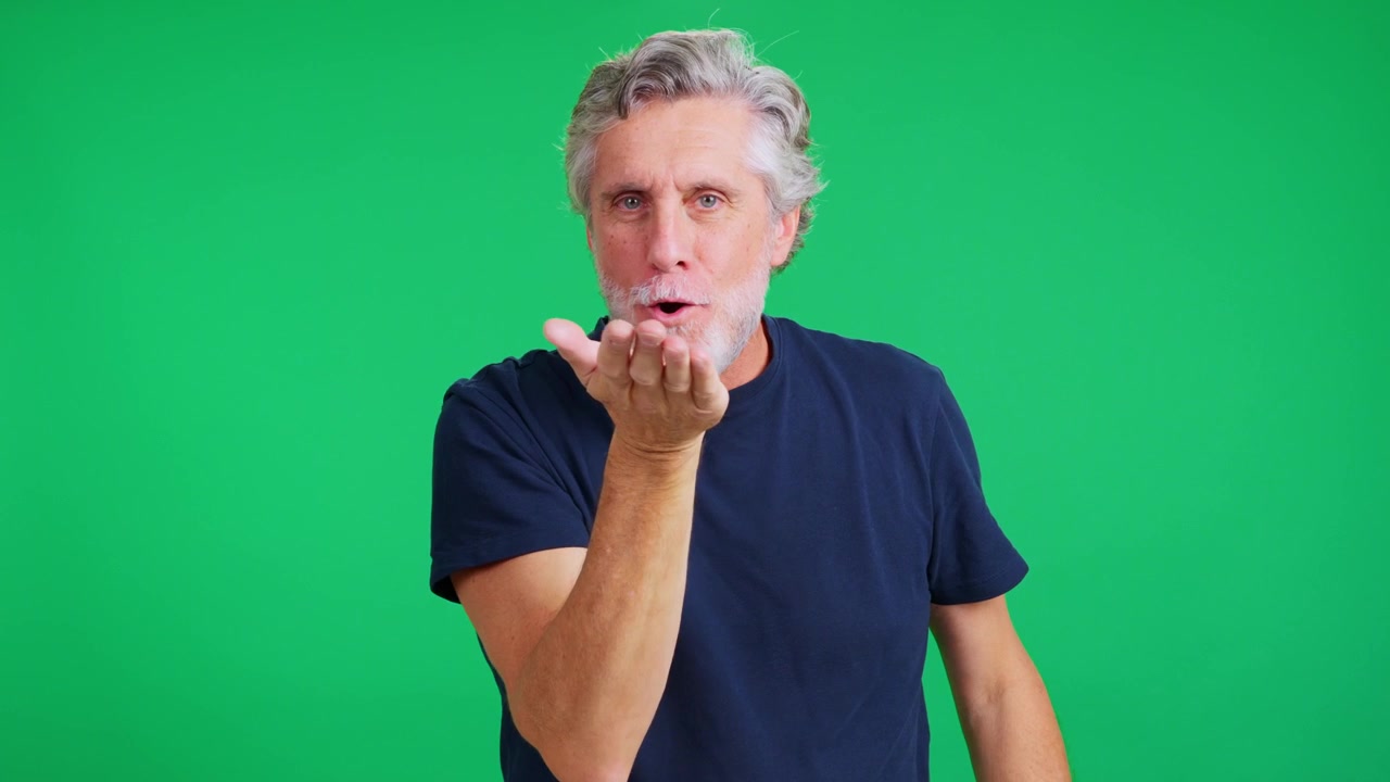 Romantic senior man blowing a kiss on green screen
