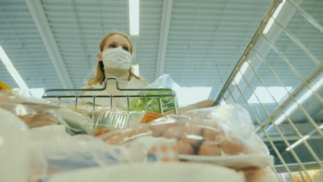 A-Woman-In-A-Protective-Mask-Walks-With-A-Shopping-Trolley-At-The-Grocery-Store