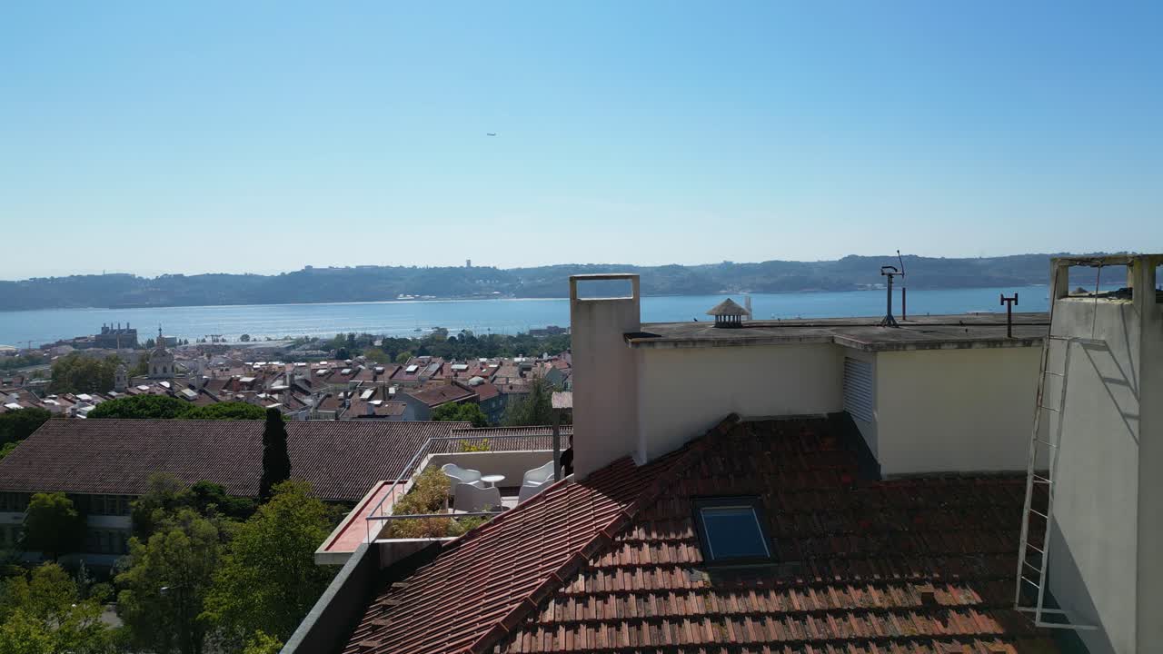 una vista del río tajo en lisboa sobre un techo de un edificio en un día soleado