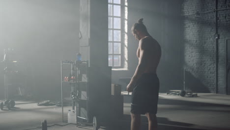 man walking in gym with sport equipment. sportsman taking rest between exercises